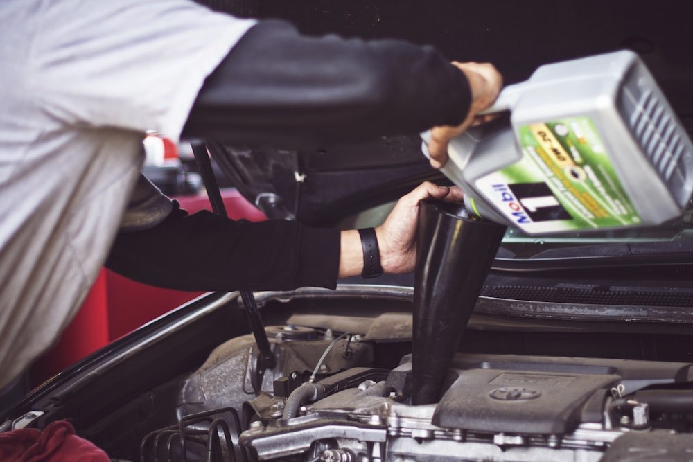Technician pouring fresh oil into a vehicle's engine